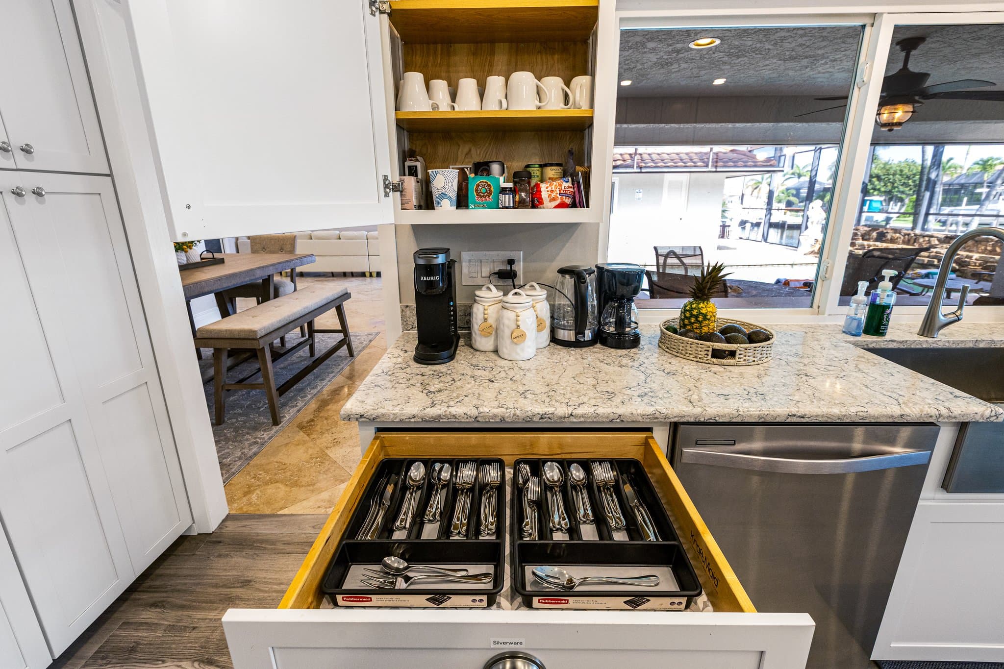 Keurig and drip coffee makers, and the stocked utensil drawer on the kitchen peninsula