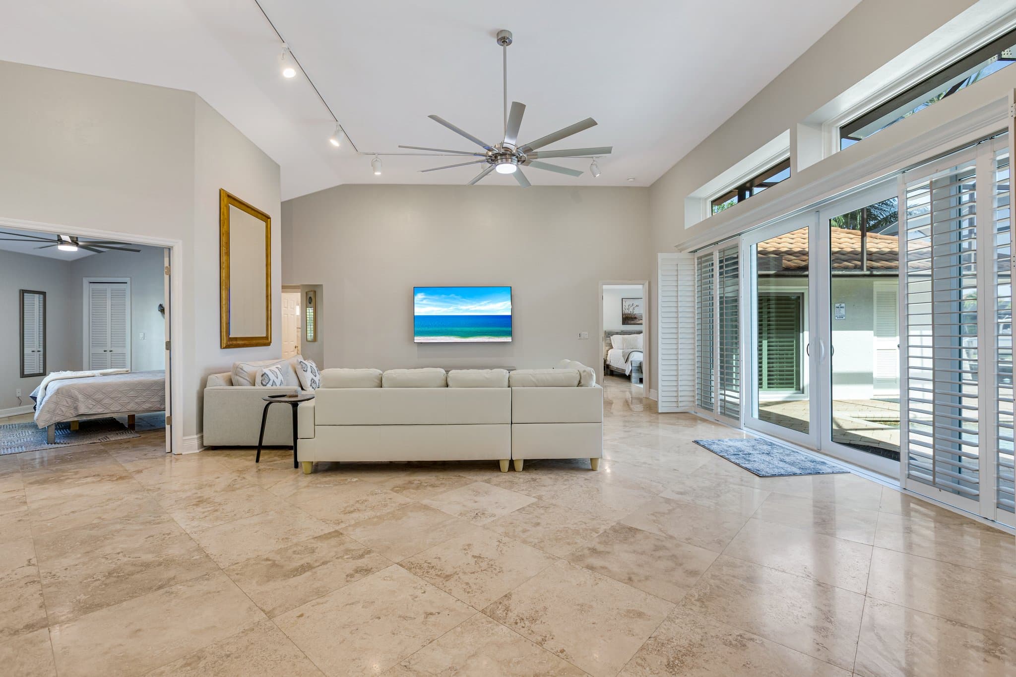 Living room sofa and wall-mounted smart TV, with sliding doors to the lanai