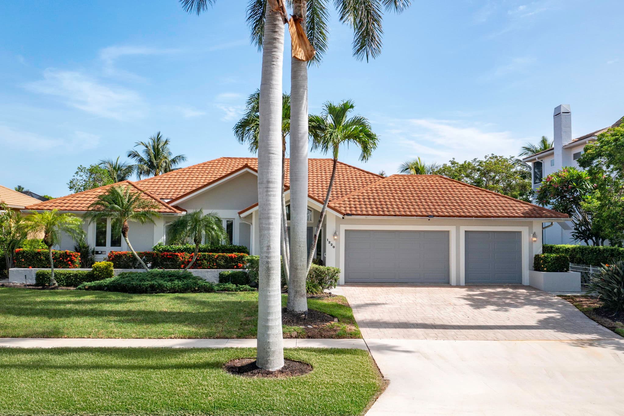 Front of the home framed by mature palms