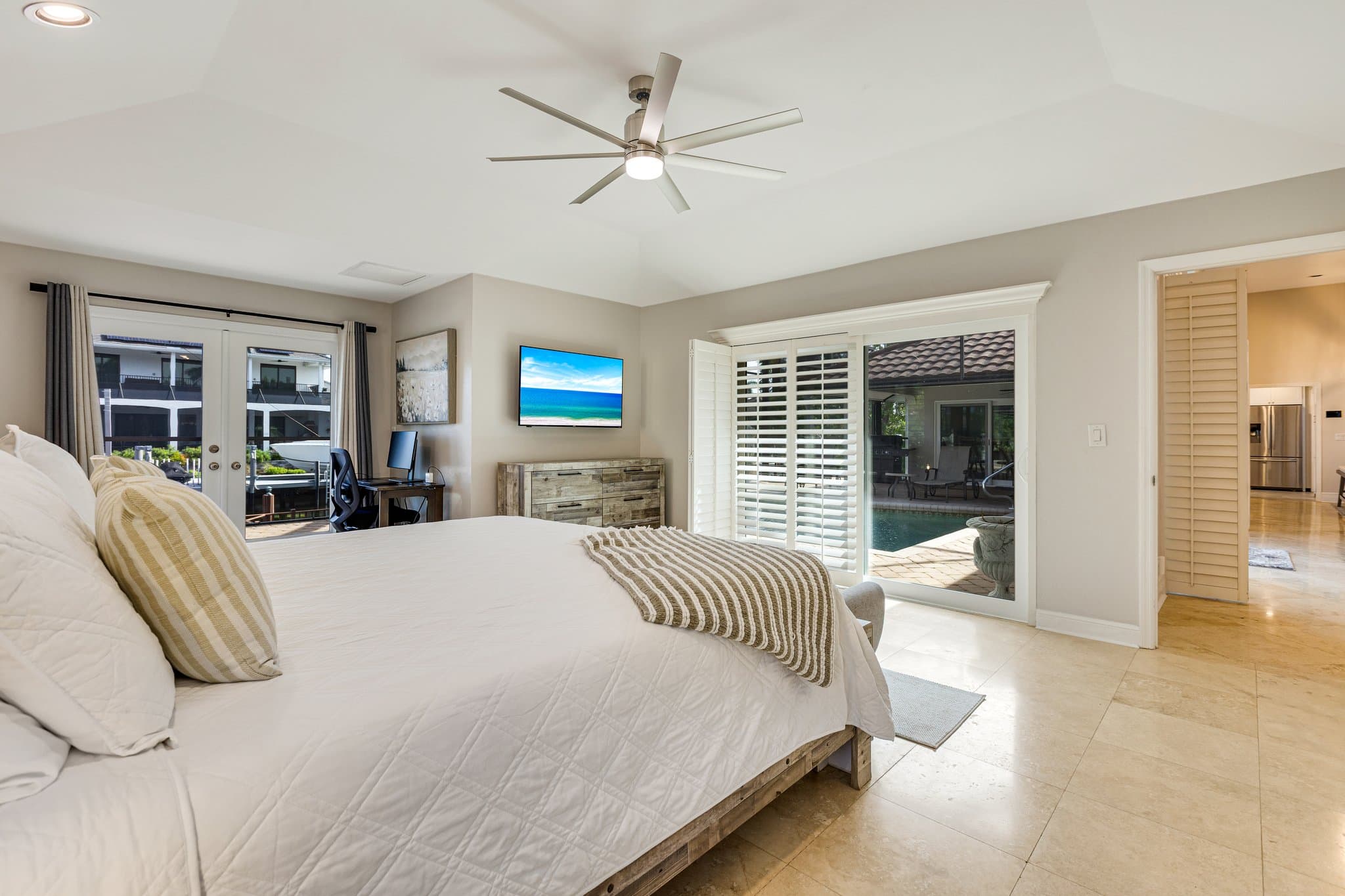 Primary bedroom sliding doors opening onto the pool deck