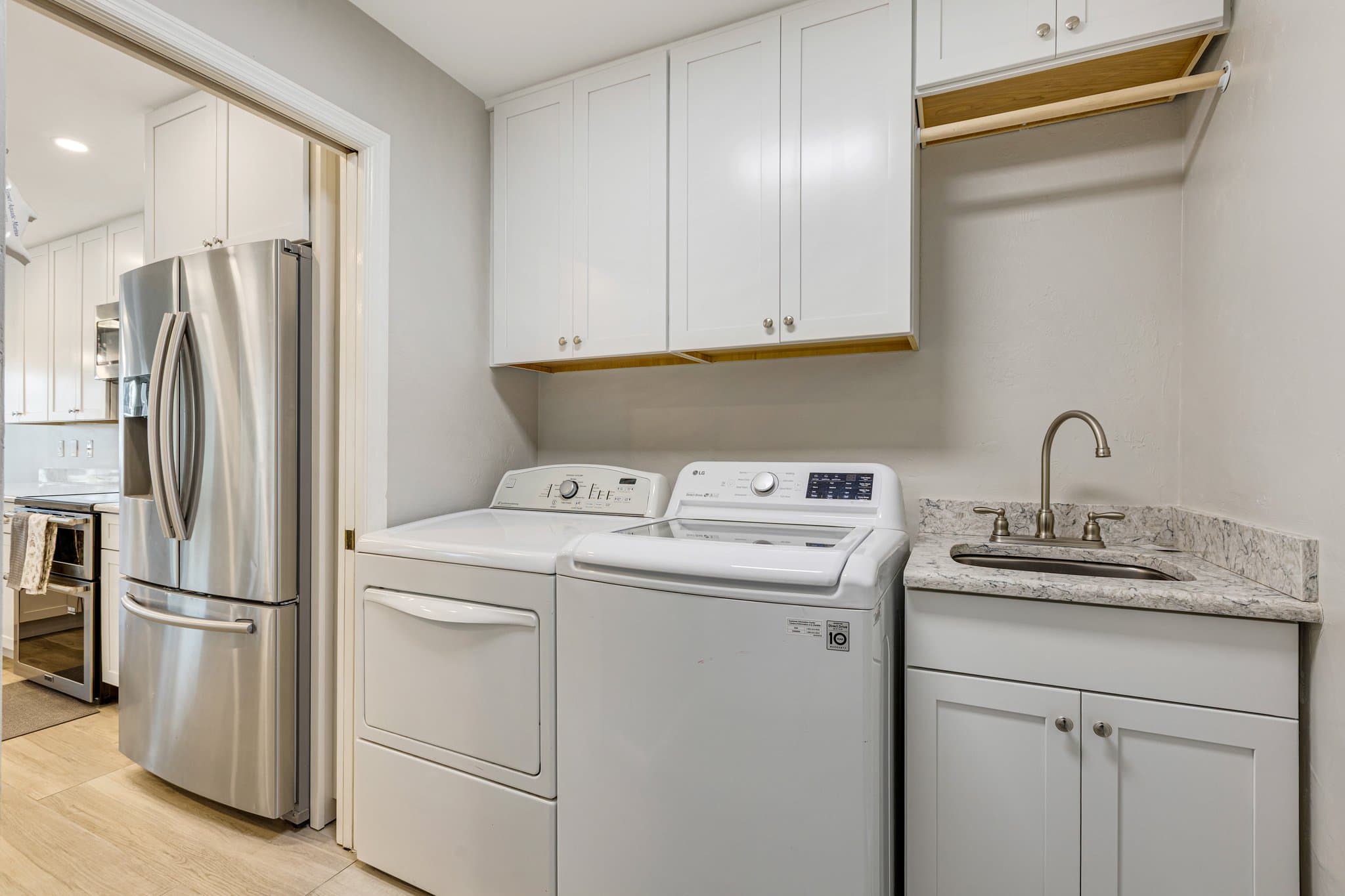 Laundry room with full-size washer, dryer and utility sink, opening onto the kitchen