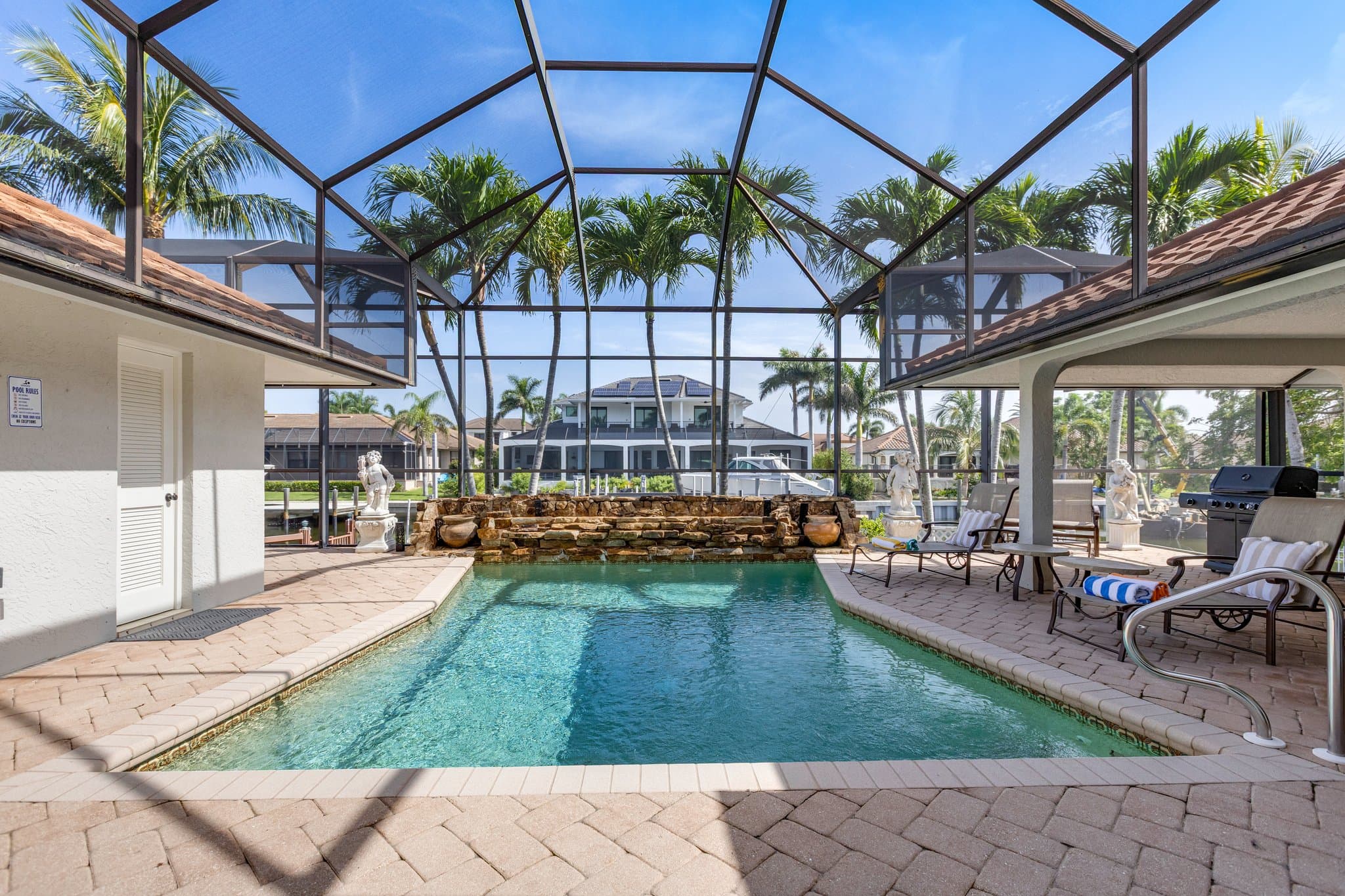 Heated pool and screened lanai looking out over the canal