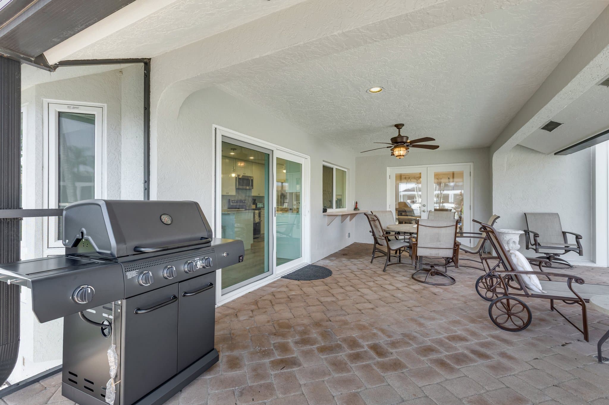 Gas grill on the covered lanai beside the sliding doors