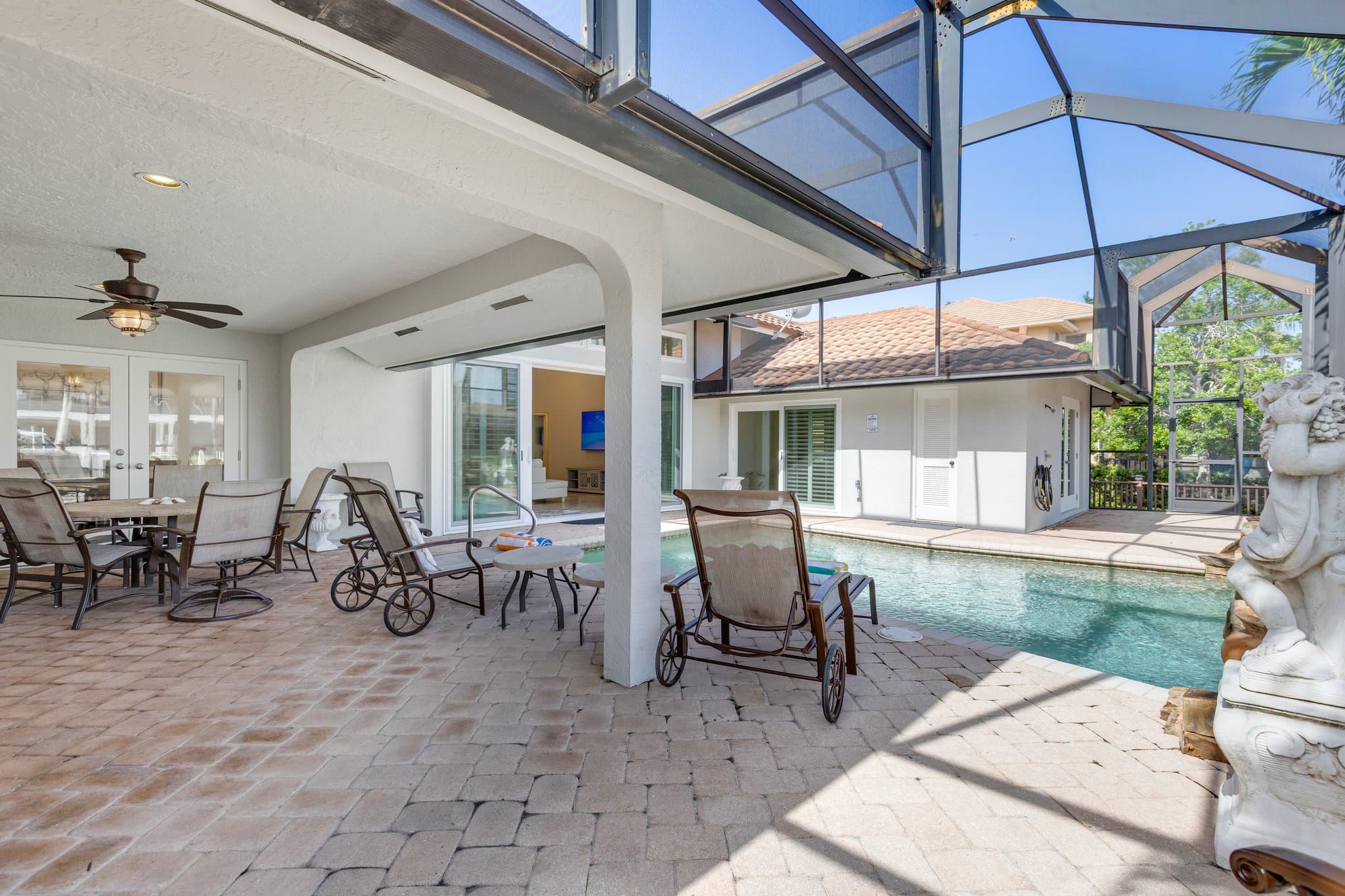 Wide view of the pool deck and covered lanai seating