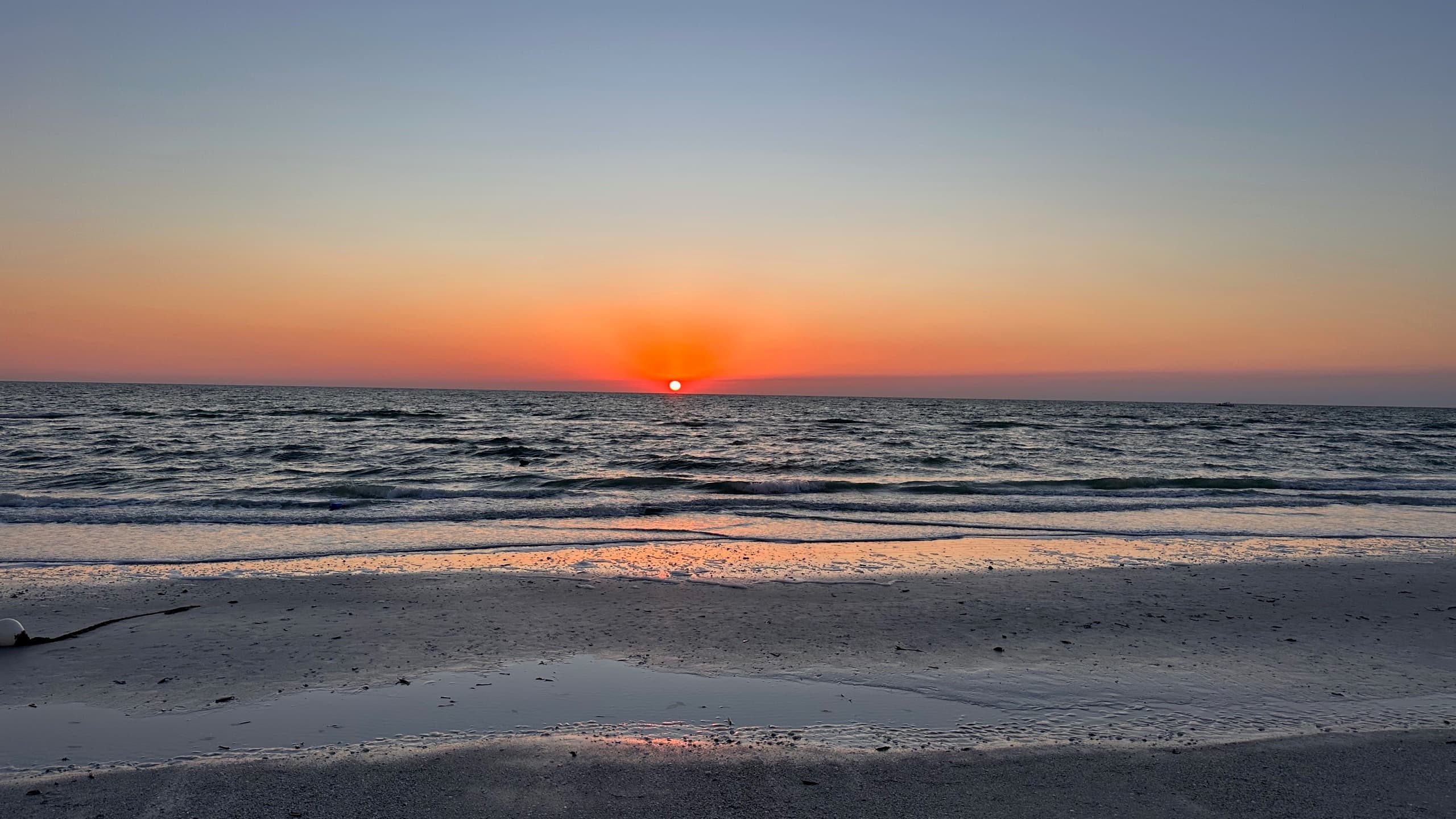 The sun dropping into the Gulf of Mexico off the island's beach