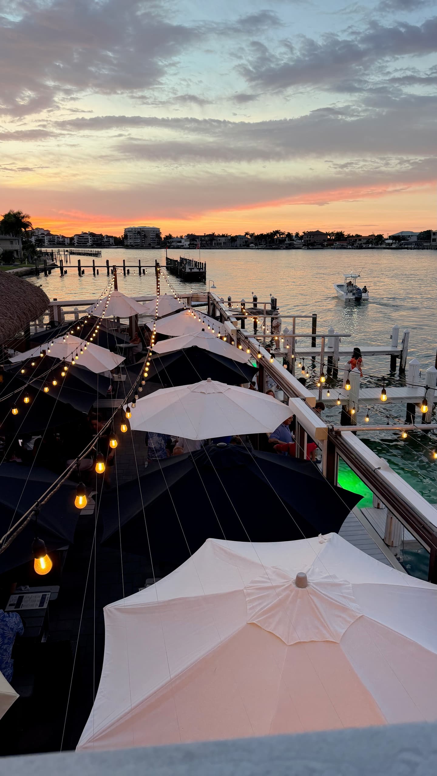 Waterfront restaurant on the island at sunset, string lights over the water