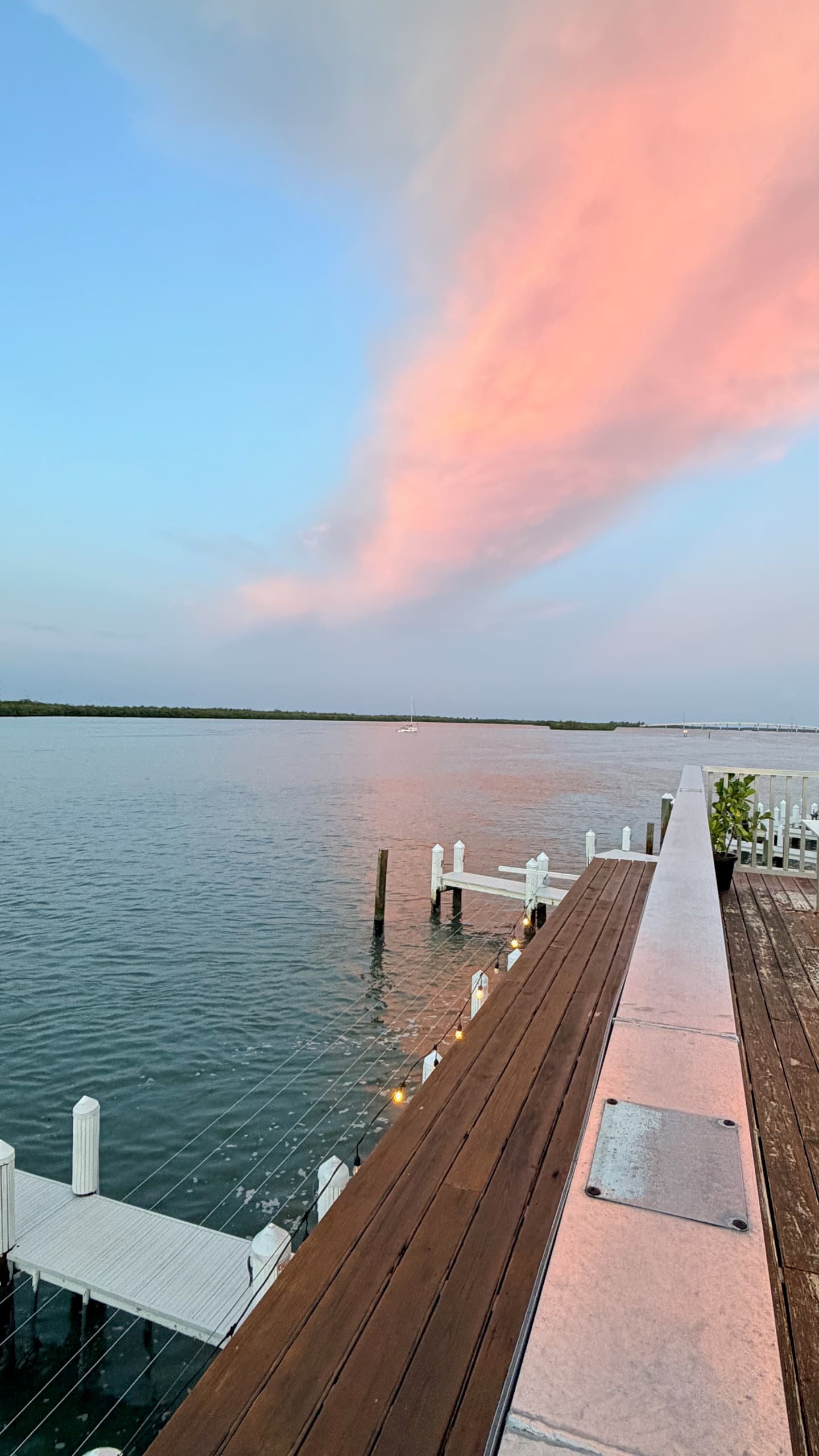 Boardwalk at dusk over the bay, mangroves on the far shore