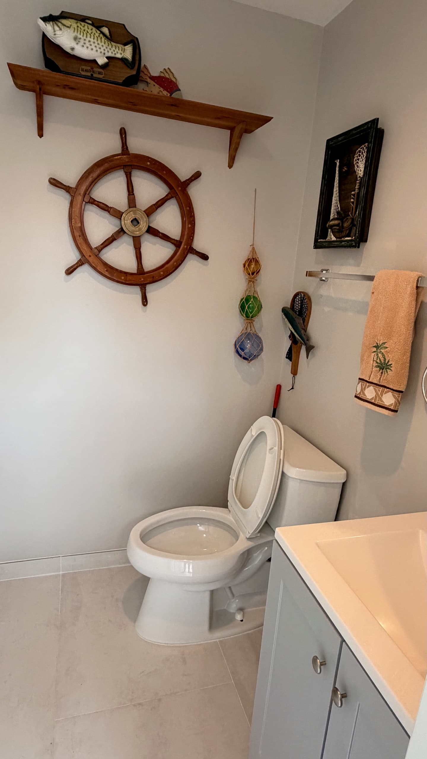 Guest half bathroom with nautical decor and a ship's wheel